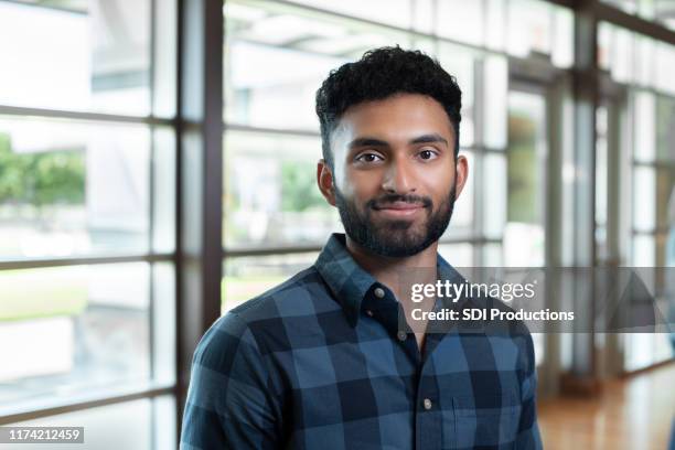 mid adult male school counselor stands in lobby - teacher man stock pictures, royalty-free photos & images