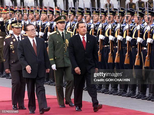 Chinese President Jiang Zemin accompanies his Venezuelan counterpart Hugo Chavez to inspect a guard-of-honour during the welcoming ceremony in...