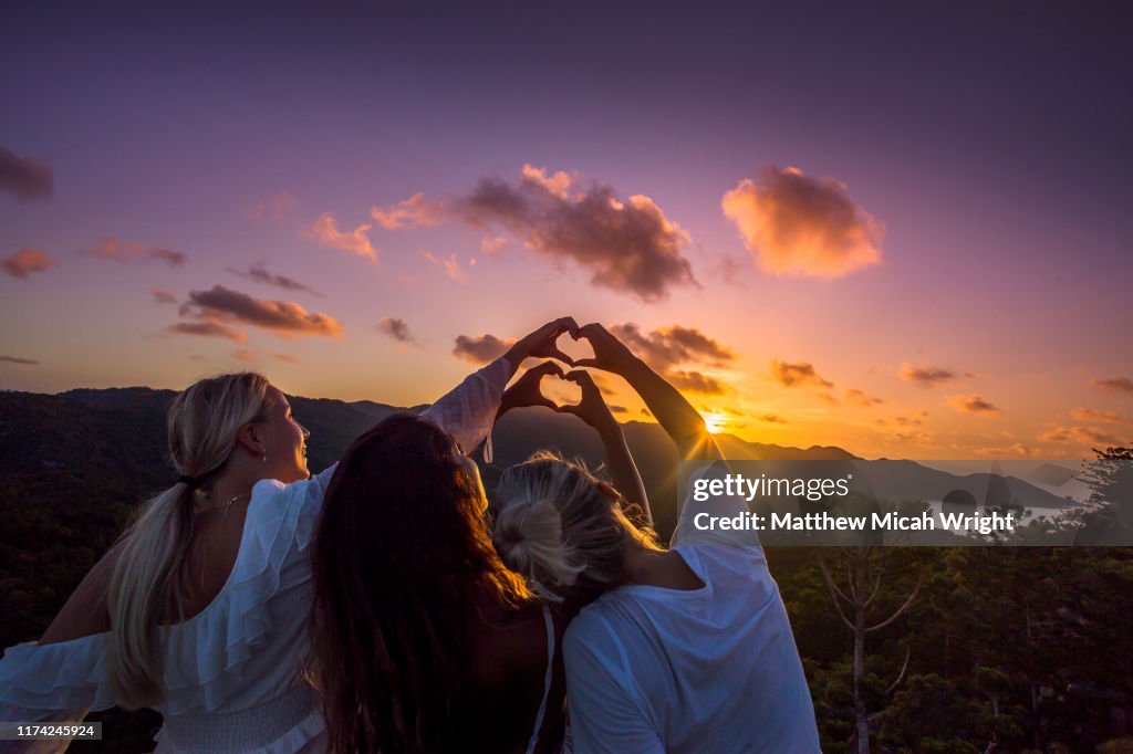 Travelers climb atop a building to watch the sunset.