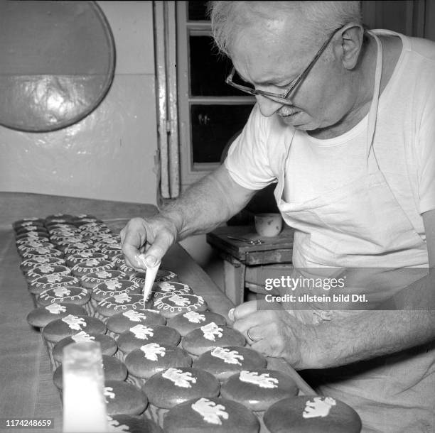 Bäcker in der Backstube dekoriert Lebkuchen; 1965