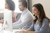 Female agent in headset consult client online using pc