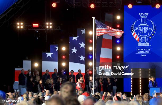 Stacy Lewis of the United States who had to withdraw from the team due to injury raises the United States flag with her daughter and husband during...