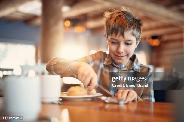 lindo niño desayunando - untar de mantequilla fotografías e imágenes de stock
