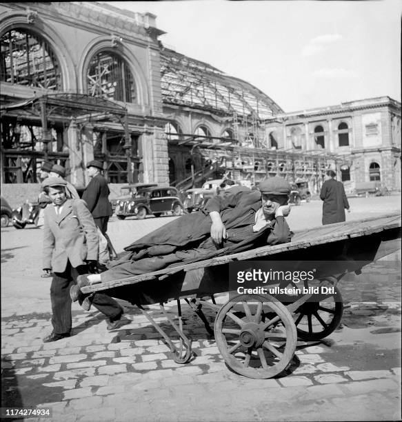 Man sleeping on baggage cart, main train station Budapest 1948