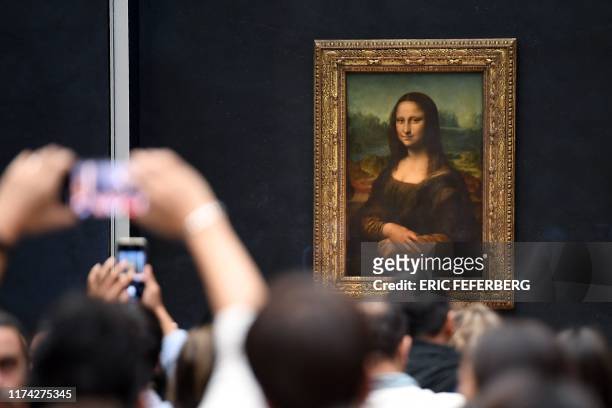 Visitors take pictures in frront of Mona Lisa after it was returned at its place at the Louvre Museum in Paris on October 7, 2019. Leonardo da...