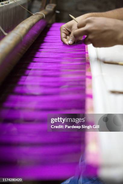 a man hand-weaving silk on a foot-powered loom in varanasi, india. - silk sari stock pictures, royalty-free photos & images