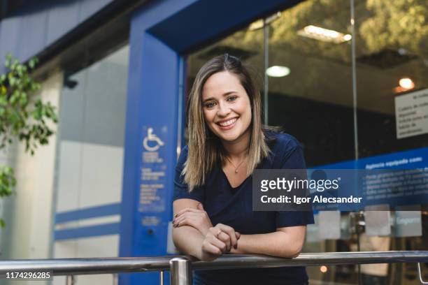 portrait of a brazilian woman in front of a financial bank - routine work stock pictures, royalty-free photos & images