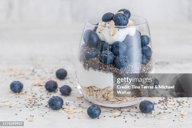 muesli with oatmeal, chia seeds, blueberries and quark in a glass on bright background. - curd cheese stock pictures, royalty-free photos & images