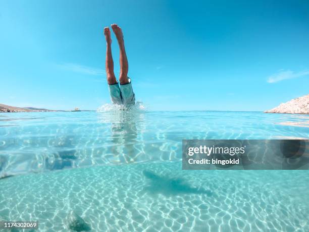 hombre saltando al mar - salto desde acantilado fotografías e imágenes de stock