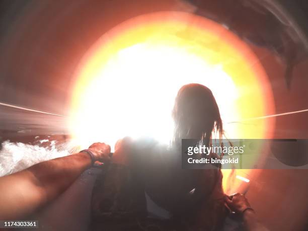 couple on a water slide going towards the light - light at the end of the tunnel stock pictures, royalty-free photos & images