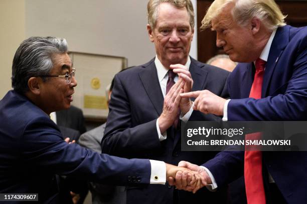 Trade Representative Robert Lighthizer watches as US President Donald Trump shakes the hand of Japan's US Ambassador Shinsuke Sugiyama during a...