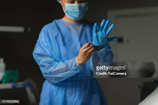 il chirurgo femminile si prepara per l'operazione medica - abbigliamento da lavoro foto e immagini stock