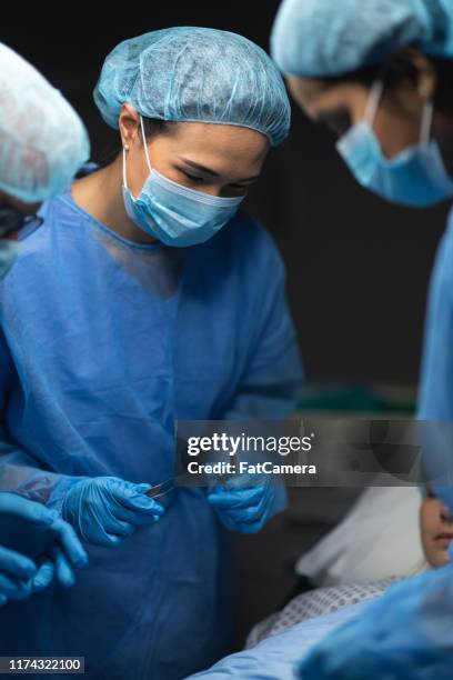 surgical team preforming operation - suture stock pictures, royalty-free photos & images