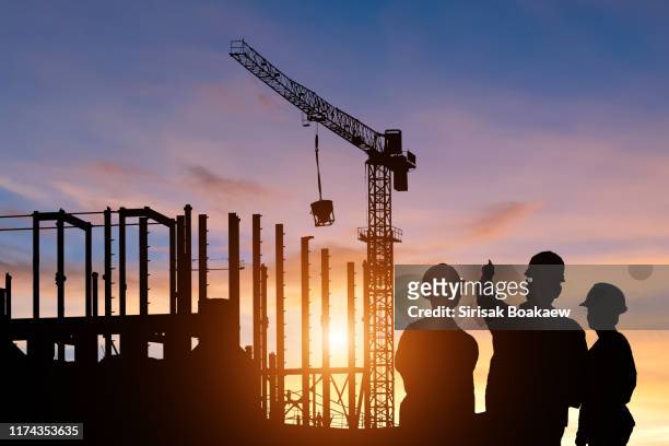 silhouette teams of business engineers looking for blueprints in construction - law building stock pictures, royalty-free photos & images
