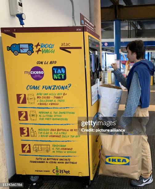 October 2019, Italy, Rom: A man cashes old plastic bottles in a vending machine for subway and bus tickets. The passengers put the plastic bottles...