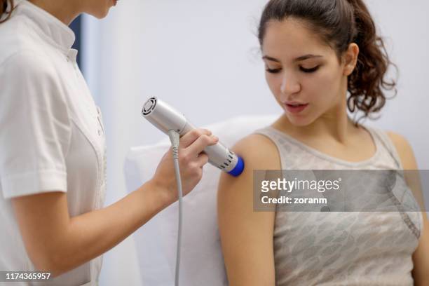 treating patient's with wave therapy instrument - physiotherapy shoulder stock pictures, royalty-free photos & images