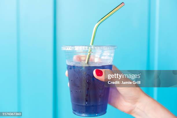 woman holding blue drink in plastic cup with metal straw - metal drinking straw stock pictures, royalty-free photos & images