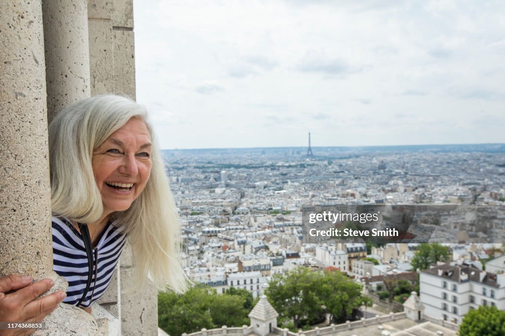 Smiling woman by cityscape from Sacre Coeur in Paris, France