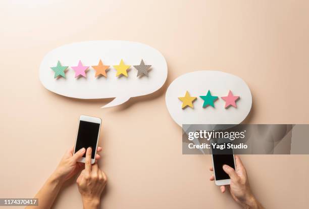 wooden five star shape with chat bubble and smart phone. - rating stock-fotos und bilder