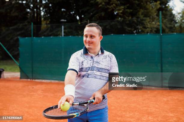 Teen boy with Down syndrome on tennis court
