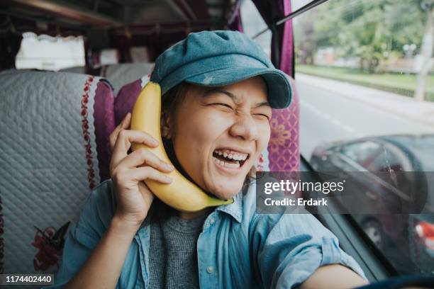 thai woman with her vacation time on the bus - banana phone stock pictures, royalty-free photos & images