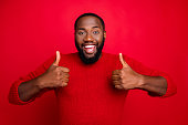 Close-up portrait of his he nice attractive cheerful cherry content positive bearded, guy showing thumbs up ad advert solution isolated over bright vivid shine red background