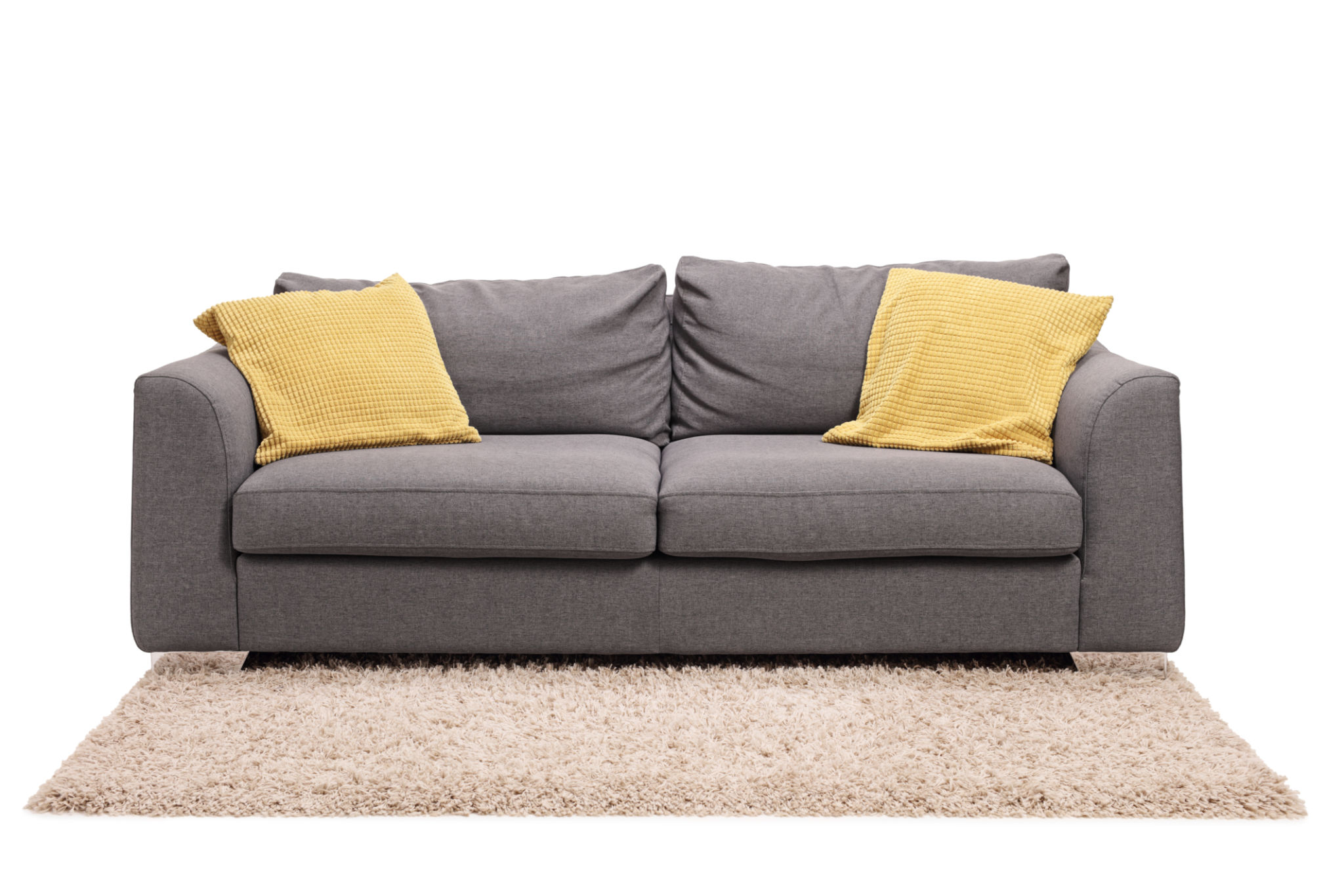 Studio shot of a grey sofa with green pillows on a carpet Studio shot of a grey sofa with green pillows on a carpet