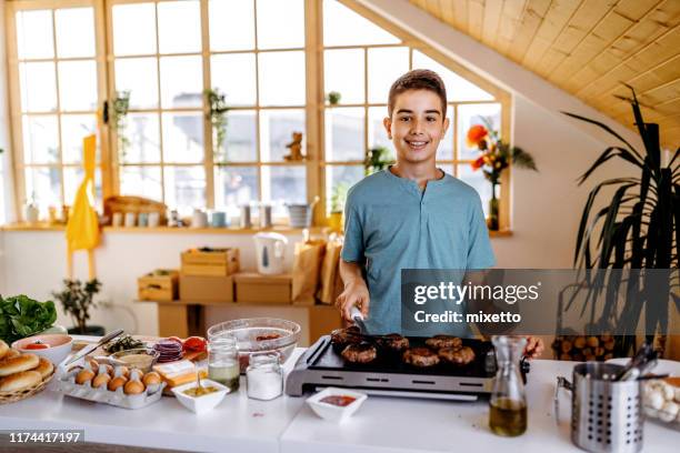 he doesn't need anyone's help for making dinner - boy cooking stock pictures, royalty-free photos & images