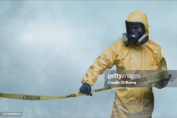 arbeiter im schutzanzug mit absperrband - gasmaske stock-fotos und bilder