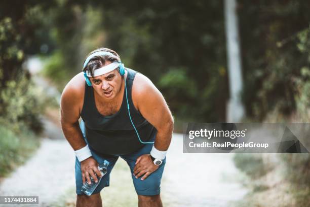 uomo grasso intenzionale che corre nel parco, senza fiato, motivazione persistente - fat guy foto e immagini stock