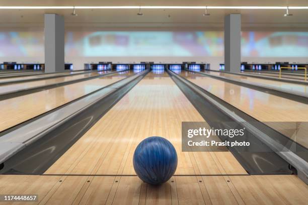 blue bowling ball on the track in the bowling center. - bowling pins stock-fotos und bilder