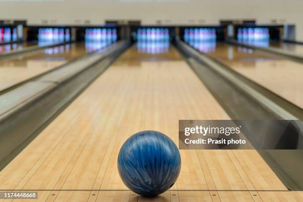 blue bowling ball on the track in the bowling center. - bowling ball and pin stock pictures, royalty-free photos & images