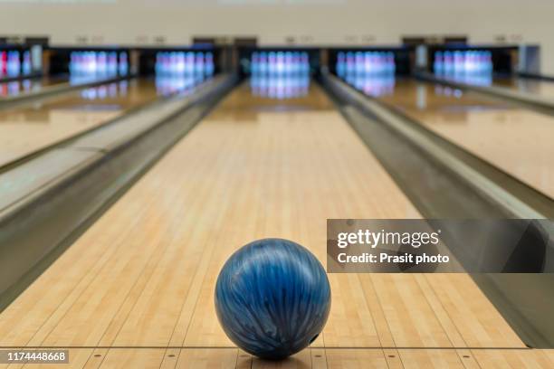 blue bowling ball on the track in the bowling center. - bowling ball stock pictures, royalty-free photos & images