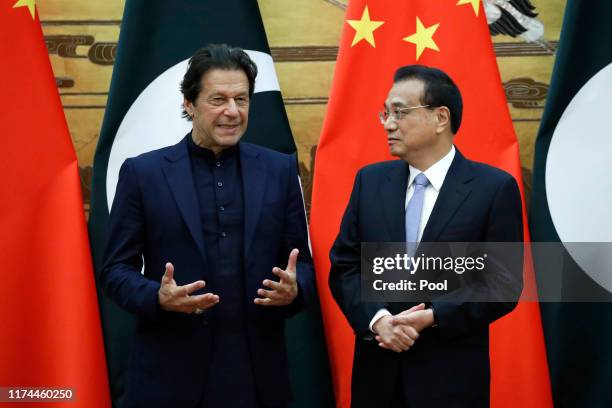 Pakistan's Prime Minister Imran Khan speaks with Chinese Premier Li Keqiang during of a signing ceremony at the Great Hall of the People in Beijing...