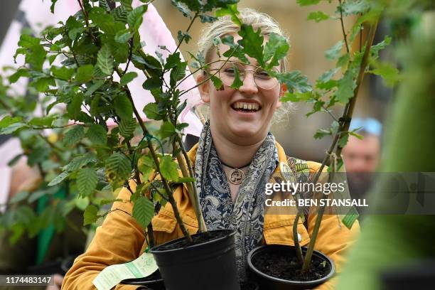Activists arrive carrying tree saplings as they protest opposite the Houses of Parliament during the second day of climate change demonstrations by...