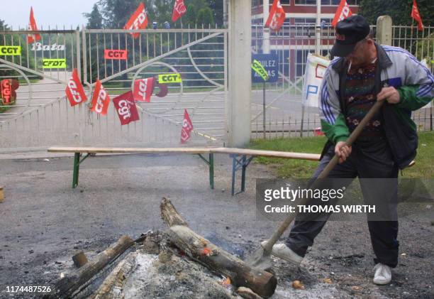 Un salarié de l'entreprise Bata de Moussey s'occupe du feu allumé à l'entrée du site, symbole de l'occupation de l'usine, le 10 juin 2001. Les...