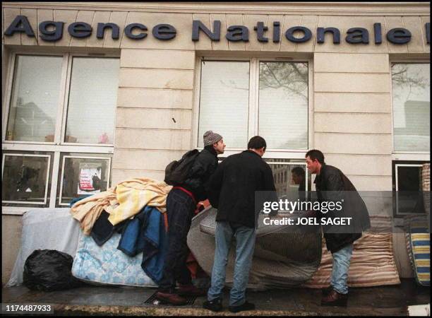 Des chômeurs de l'association AC! ramassent les matelas jetés dans la rue, le 14 février, par les forces de l'ordre, lors de l'expulsion de l'ANPE de...