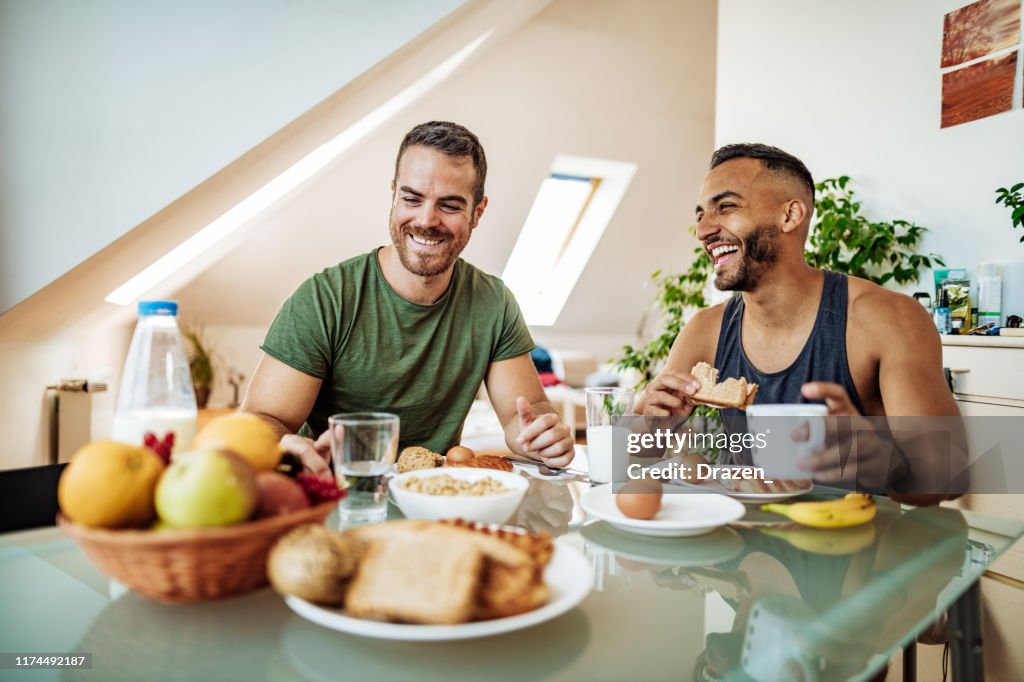 Schwules Paar mit gesundem Frühstück in gemütlichen Bed and Breakfast
