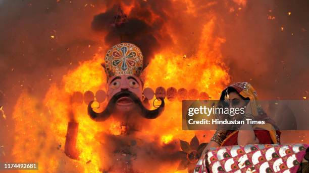 Woman dressed as the Hindu goddess Sita puts her fingers into her ears as an effigy of Ravana goes up in flames in Jammu city, on October 8, 2019 in...