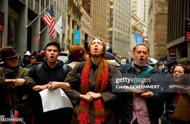 Occupy Wall Street protestors lock arms and block access to the New York Stock Exchange area November 17, 2011 in New York. Some 1,000 protesters...