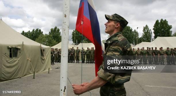 Russian soldier raises the Russian flag at a border guard outpost in the South Ossetian village of Girei on Border Guards' Day May 28, 2009. The...