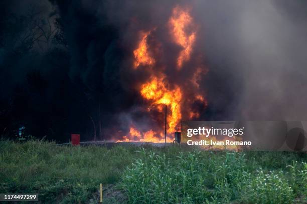 The flames rise over a field during a fire in a factory of plastic containers for car batteries on September 13, 2019 in Avellino, Italy. The fire...