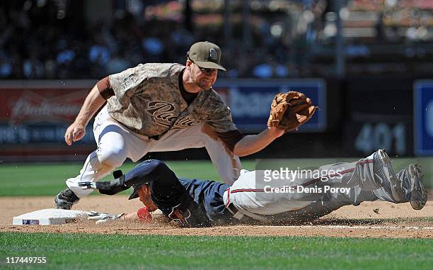 Jordan Schafer of the Atlanta Braves gets back to third base under the tag of Chase Headley of the San Diego Padres after leading off during the...