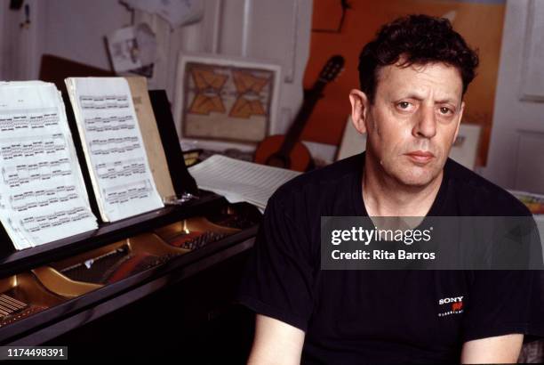 Portrait of American composer Philip Glass as he sits at a piano in an East Village apartment, New York, New York, September 11, 1990.