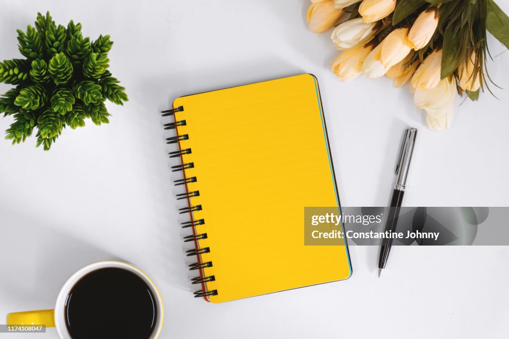 Yellow Notebook and Coffee Mug on Work Desk