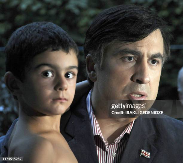 Georgia's President Mikheil Saakashvili holds a child as he meets with refugees in Tbilisi, on August 17, 2008. Saakashvili signed the ceasefire on...