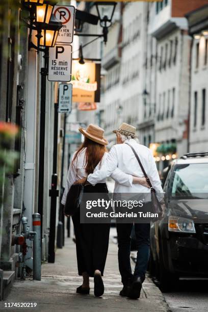 couple of lovers walking in the old montreal, quebec, canada - couple de vieux stockfoto's en -beelden