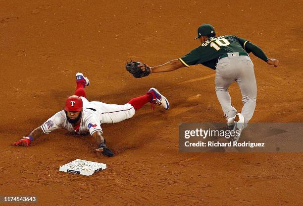 Danny Santana of the Texas Rangers steals second ahead of the tag by Marcus Semien of the Oakland Athletics in the second inning at Globe Life Park...