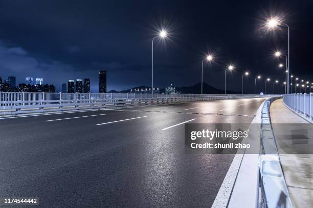 sea-crossing bridge after rain at night - empty road stockfoto's en -beelden