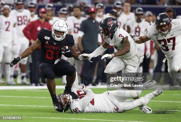 Patrick Carr of the Houston Cougars is tackled by Bryce Beekman of the Washington State Cougars as Daniel Isom assists during the first half of the...